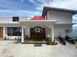 a white house with motorcycles parked in front of it at Delohighs in Kalimpong