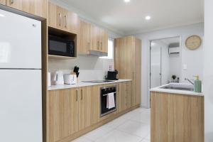 a kitchen with wooden cabinets and a sink and a refrigerator at Super Host and New Listing in Brisbane