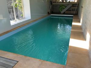 een zwembad met turquoise water in een huis bij Gîte N°2 : YLMADI in Cahors
