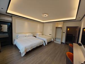 a hotel room with two beds with white sheets at Guilin Meishe Homestay in Guilin