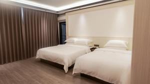 two beds sitting next to each other in a room at Guilin Meishe Homestay in Guilin