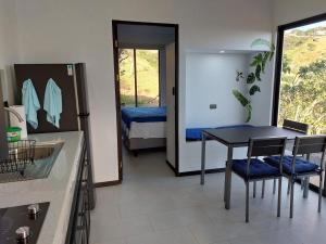 1 dormitorio y cocina con mesa y sillas. en Apartamentito moderno con vista en Monteverde, en Cebadilla