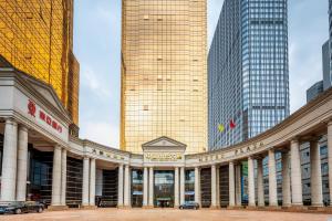 a large building in front of some tall buildings at China Mayors Plaza - Free shuttle between hotel and Exhibition Center & Exhibitor registration Counter during Canton Fair in Guangzhou