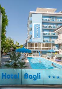 um hotel com piscina em frente a um edifício em Hotel Bagli em Rimini