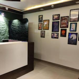 Cette chambre est dotée d'un mur blanc avec des photos. dans l'établissement Hotel Route55 Darjeeling, à Darjeeling
