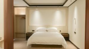 a bedroom with a white bed with two pillows at Guilin Meishe Homestay in Guilin