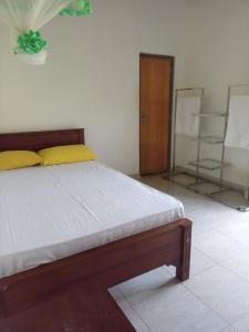 een slaapkamer met een bed met gele kussens bij Green Villa Home in Anuradhapura