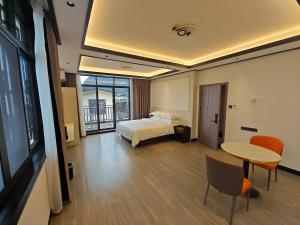 桂林市にあるGuilin Meishe Homestayのベッドとテーブルが備わるホテルルームです。