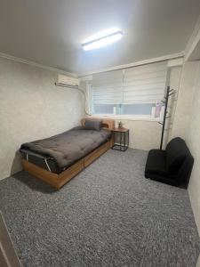 a bedroom with a bed and a chair and a window at Apartment in Gangnam in Seoul