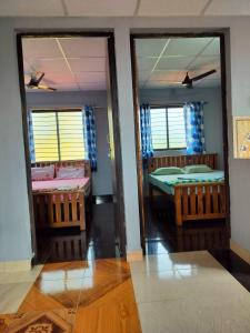 um quarto com três camas e duas janelas em KENSONS BUDGETSTAY NON AC FREE WIFI and PARKING em Mangalore