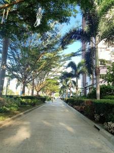 una calle con palmeras y una persona caminando por la calle en Studio type condo - Matina Enclaves Residences Davao City, en Davao City