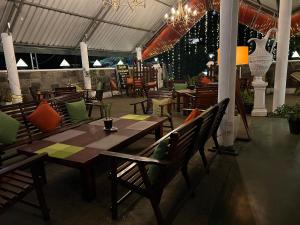 ein Restaurant mit einem Holztisch und Stühlen in der Unterkunft Hill Cool Hotel & Restaurant in Hatton