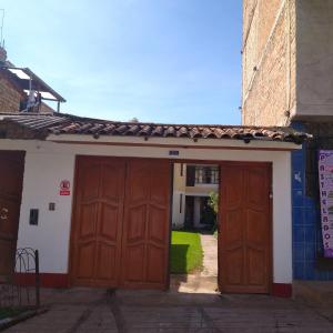 two large wooden doors on a building with at La Chinita hospedaje Cajamarca in Cajamarca