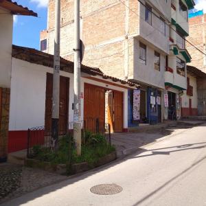 an empty street with a building and a pole at La Chinita hospedaje Cajamarca in Cajamarca