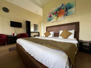 - une chambre avec un grand lit dans une chambre d'hôtel dans l'établissement Hill Cool Hotel & Restaurant, à Hatton