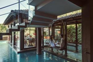 a man and woman sitting on a bench next to a swimming pool at Aalia Villas Anjuna, Goa by Aalia Collection in Anjuna