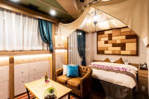 a bedroom with a bed and a couch and a table at Hotel Bali An Resort Shinjuku Forest in Tokyo