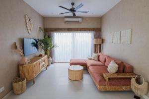 un soggiorno con divano e TV di Gili Boho Villas - Aesthetic Private Pool Villas a Gili Trawangan