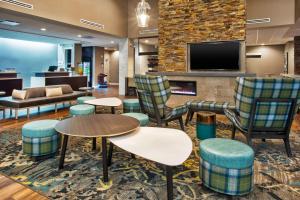 vestíbulo con sillas, mesas y TV en Residence Inn By Marriott Wichita Falls, en Wichita Falls