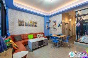 uma sala de estar com um sofá e uma mesa em Baby Dolphin em Hengchun South Gate