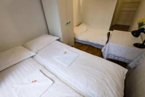 2 camas en una habitación pequeña con sábanas blancas en Pest-port apartment room-5 Private apartment, en Budapest