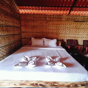 a bed in a room with two bows on it at Osho's Organic Resort Hampi in Hampi