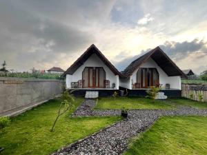 a small house with a grassy yard in front of it at Serene Wilderness Villa Near Batur Natural Hot Spring in Kintamani