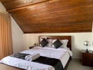 a bedroom with a large bed with a wooden ceiling at Serene Wilderness Villa Near Batur Natural Hot Spring in Kintamani