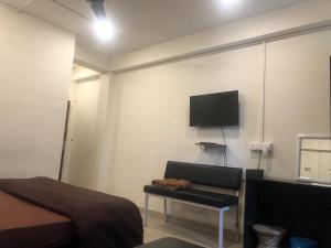 1 dormitorio con 1 cama y TV en la pared en THE Pi HOTEL IMPHAL MANIPUR, en Imphal