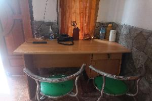 a wooden table with two chairs in a room at OYO 93582 Liani Homestay Syariah in Kuripan