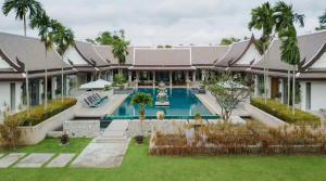 an exterior view of a house with a swimming pool at Oasis Villa Pattaya in Ban Bung