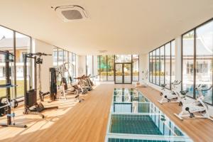 a gym with a swimming pool and treadmills at Oasis Villa Pattaya in Ban Bung