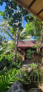 a building with trees and plants in front of it at Villas Light House - Eco-Traditional Joglo in Gili Trawangan