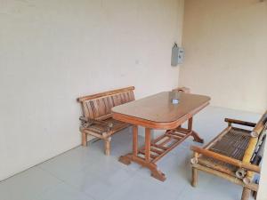 - une table en bois et 2 chaises dans une chambre dans l'établissement OYO 93590 Penginapan Palapa 10 Syariah, à Bandar Lampung