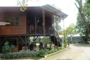 una casa de madera con una escalera que conduce a ella en OYO 93595 Puri Adem 86 Syariah Bunkbed, en Yogyakarta
