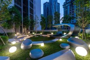 un parco con un gruppo di sgabelli nell'erba di Scarletz Suites KLCC Deluxe Studio Room Single Double Bed a Kuala Lumpur