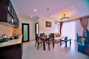 a kitchen and a living room with a table and a couch at Kosmos Apart Hotel Phu Quoc - Night market & Walkin to beach in Phú Quốc