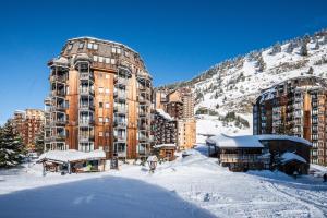 ein großes Gebäude im Schnee vor einem Berg in der Unterkunft Appartement - Pas du lac - Avoriaz in Avoriaz