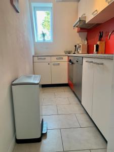 a kitchen with white cabinets and a tile floor at Schleimöwe in Borgwedel
