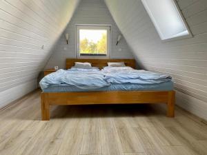 a bedroom with a bed in a attic with a window at Schleimöwe in Borgwedel