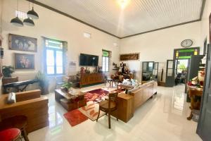 a large living room with a couch and a tv at OYO Homes 93608 YY's House Syariah in Klaten