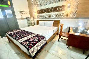 um quarto com uma cama e uma secretária e uma cama sidx sidx em OYO Homes 93608 YY's House Syariah em Klaten
