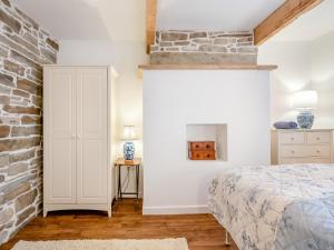 a bedroom with a bed and a brick wall at Winter Cottage 