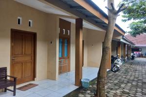 a house with a motorcycle parked next to a door at SPOT ON 93606 Juan Kostel 3 in Purwokerto