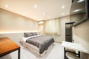 1 dormitorio con cama y escritorio en Hey Gunsan Hotel en Gunsan