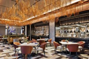 a restaurant with tables and chairs and a bar at mesm Tokyo, Autograph Collection in Tokyo