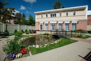 a house with a pond in front of it at History Hotel in Vologda