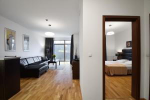 Diune Resort & Apartamenty في كولوبرزيغ: غرفة معيشة مع سرير وأريكة