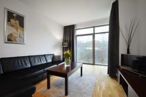 a living room with a black couch and a coffee table at Diune Resort & Apartamenty in Kołobrzeg