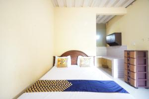 een slaapkamer met een bed in een kamer bij SPOT ON 93612 Kencana Homestay Syariah in Mojokerto